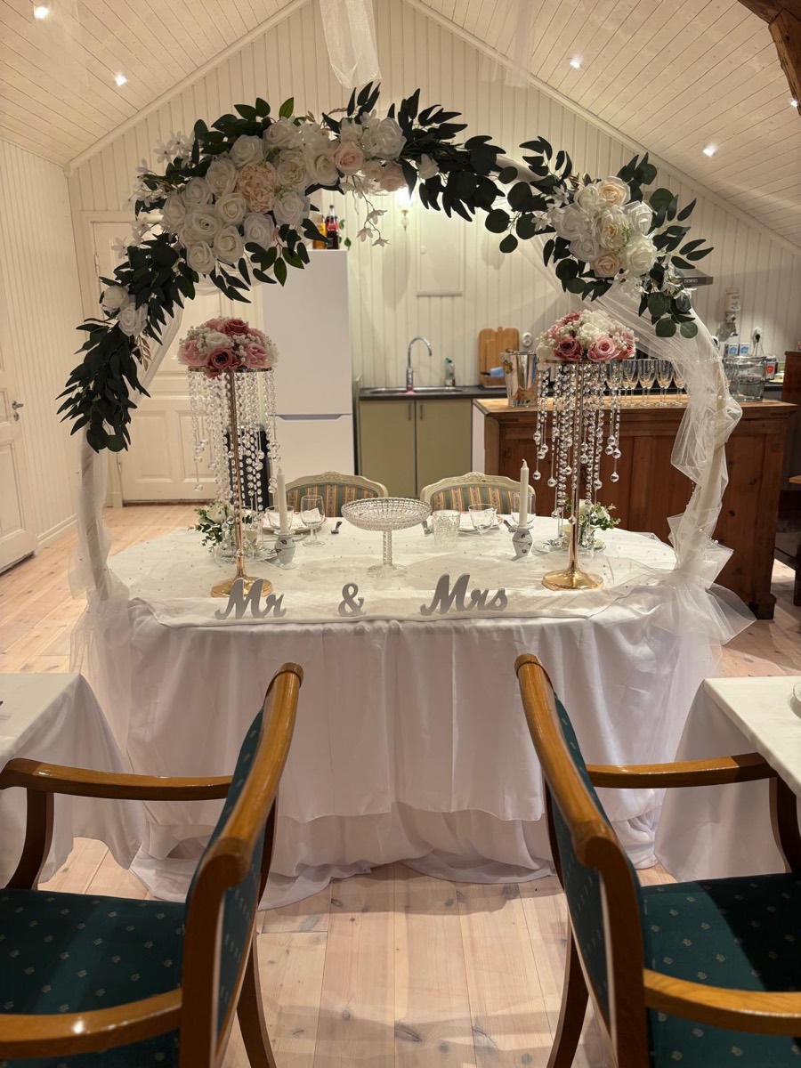 Brudbord med blomsterbåge i vita och rosa rosor samt Mr & Mrs-skylt